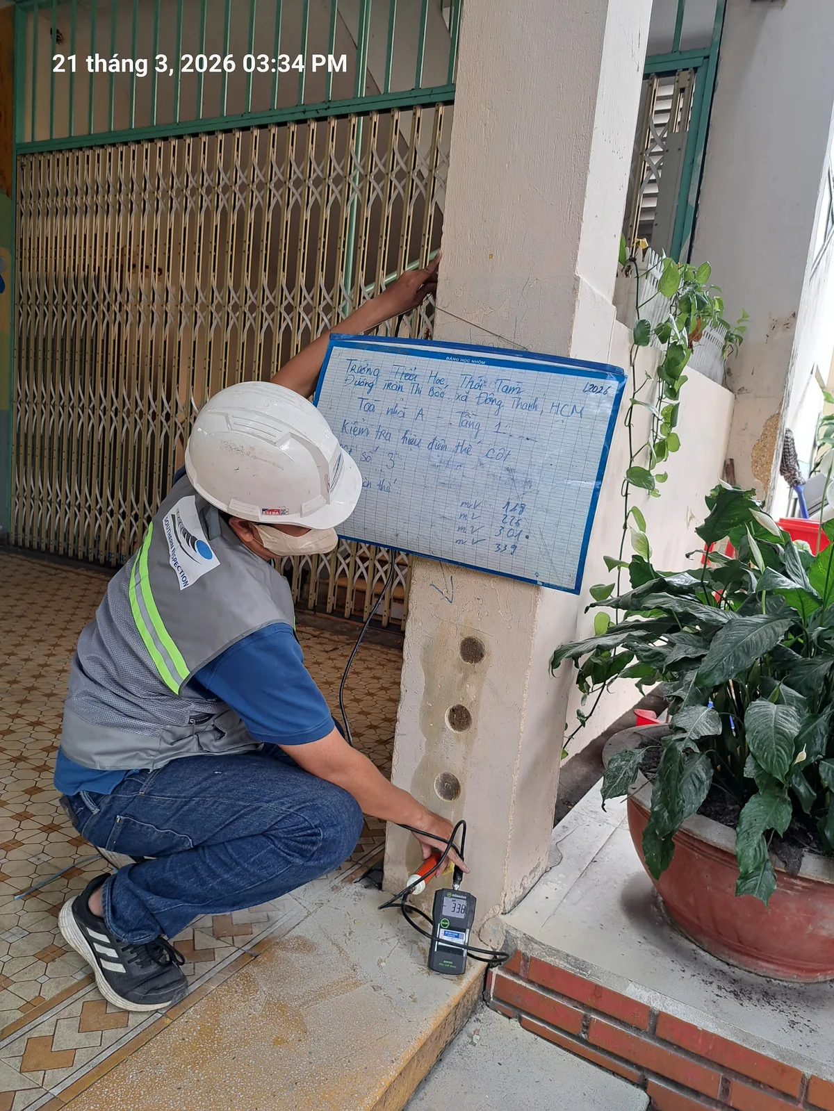 Kỹ thuật viên thực hiện kiểm định công trình tại trụ bê tông